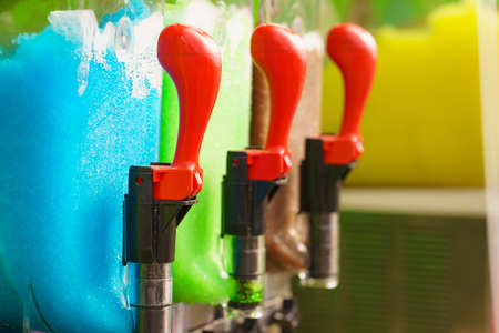 Slush machine. Slushy ice made colorful drink refreshing during summer. Granita distributor. Different flavors.の写真素材