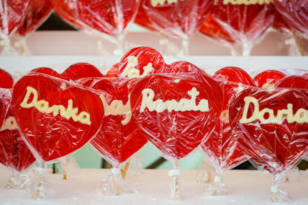 Stall with heart shaped red lollipops on sticks with polish names