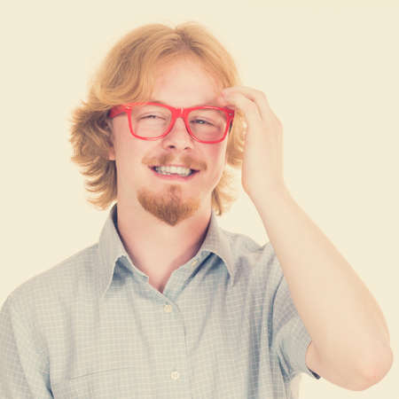 Cheerful funny looking nerdy guy with ginger hair and eyeglasses having beard.