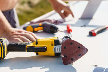 Male hands repair caravan motor home roof.
