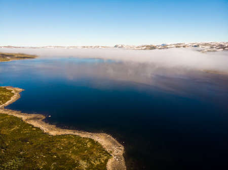 Aerial view. Hardangervidda mountain plateau, Norway landscape. Morning time, clouds over lake water. National tourist Hardangervidda route.の写真素材