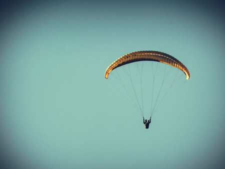 Paragliding. Extreme sport Paraglider silhouette flying in the blue sky.の写真素材