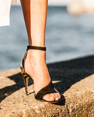 Woman feet wearing fashionable high heels summer shoes.の写真素材