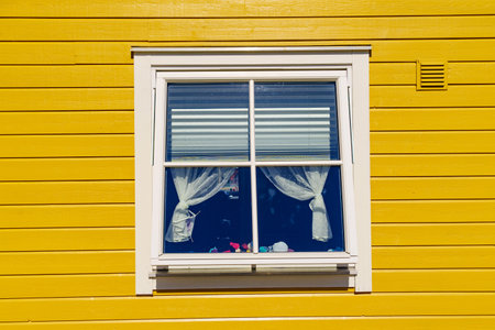 Window on yellow wall house, fasade architecture detail, scandinavian building