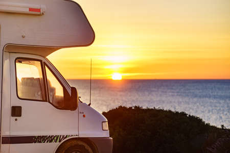 Caravan recreational vehicle at sunrise on mediterranean coast in Spain. Camping on nature beach....