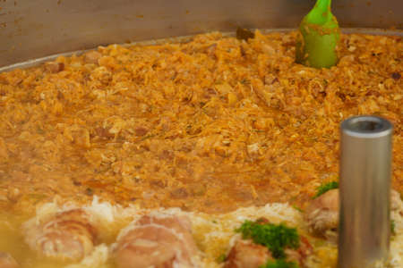 Cooked cabbage and many pork knuckle topping with fresh green dill in big pot. Polish traditional...