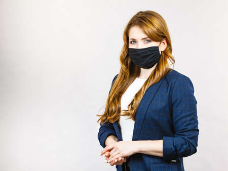 Business woman using protective face black mask against virus. virus prevention, preventive gear.