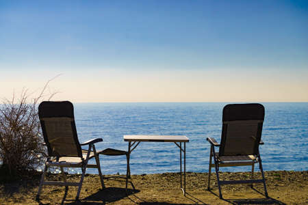 Tourist table and chairs on coast sea shore, Spain.