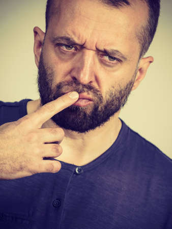 Confused adult man seeking for solution. Thinking about something, trying to solve problemの写真素材