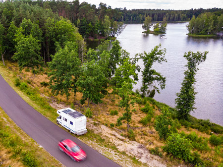 Aerial view. Camper on roadside at lake in Tuchola national park, Poland. Holidays with motor home, caravan vacation.の写真素材
