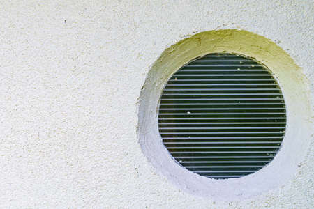 Plastic round window porthole in wall of house for lightingの写真素材