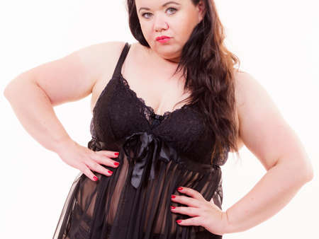 Plus size fat woman wearing black lace lingerie. Overweight voluptuous model in underwear set clothing on whiteの写真素材