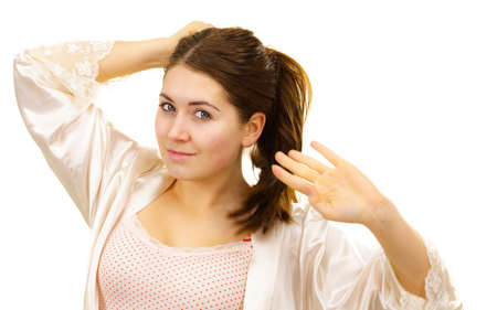 Young woman in underwear without makeup untying her long brown hair. Natural beauty.の写真素材