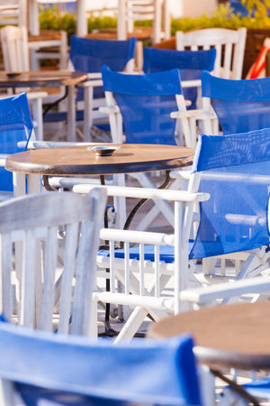 Blue white table and chairs open cafe outdoor restaurant in Greece. Summer vacation on resort.の写真素材