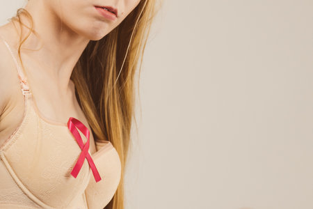 Woman wih pink ribbon on chest. Treatment and prevention of breast cancer.の写真素材