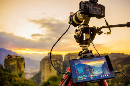 Professional camera on tripod taking picture film video from the Holy Trinity Monastery on cliff at...