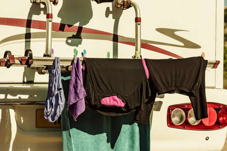 Wild camping on nature. Caravan vehicle with clothes hanging to dry. Holidays with motor home.