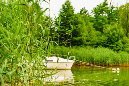 Boat yacht on lake attached to mooring buoy. Tuchola national park in Poland. Yachting, holidays concept.の写真素材
