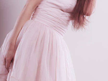 Beauty, fashion and elegant people concept - young slim woman in bright dress closeup, part of body waistlineの写真素材