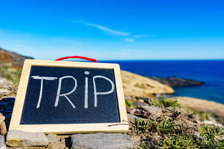 Black board with word trip against spanish sea coast. Landscape of Calblanque Park in Murcia Spain. Travel and holidays.の写真素材