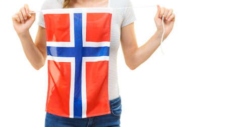 Blonde student girl unrecognizable young woman holding norwegian flag. Education and travel.の写真素材