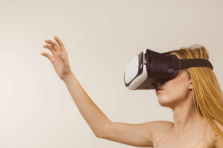 Young woman wearing virtual reality goggles headset, vr box. Connection, technology, new generation...