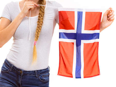 Blonde student girl unrecognizable young woman holding norwegian flag. Education and travel.の写真素材