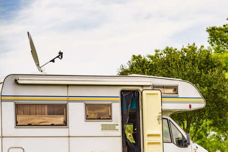 Travel holidays in motorhome. Caravan with satellite dish on roof camping on green nature. .のeditorial素材