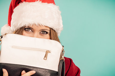 Female in santa claus clothing holding present handbag purse.の写真素材