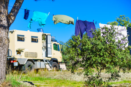 Camping on nature, rv road trip. Laundry clothes hanging to dry by camper, lorry motor home.の写真素材