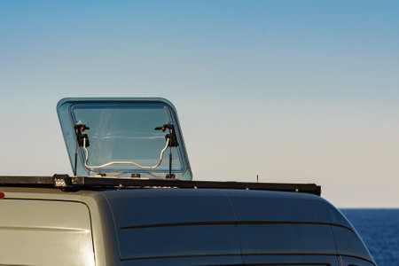 Sunroof, raisable panel window on roof top of rv camper van against blue sky. Traveling by motor home.の写真素材
