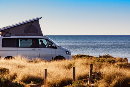 Camper van with roof top tent camping on mediterranean sea coast. Holidays and travel in motorhome.の写真素材