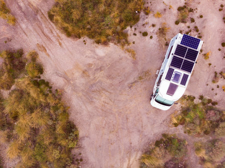 aerial view. Camper with solar photovoltaic panels on roof camping on nature. Electricity on caravan vacation. Renewable free energy.の写真素材