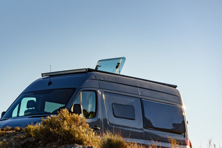Sunroof, raisable panel window on roof top of rv camper van against blue sky. Traveling by motor home.の写真素材