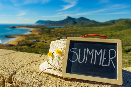 Black board with word summer against spanish sea coast. Landscape of Calblanque Park in Murcia Spain. Travel and holidays.の写真素材