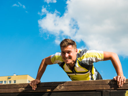 Young handsome man working out outdoors. Sporty guy flexing his muscles doing push ups.の写真素材