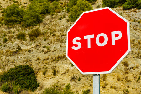 Traffic stop red sign by the road in mountains