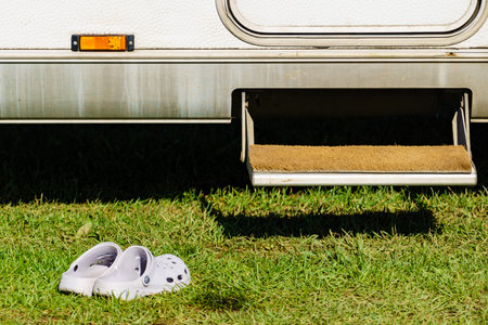 Shoes slippers in front of camper car step. Traveling with mobile home, holidays.の写真素材
