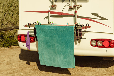 Wild camping on nature. Caravan vehicle with clothes hanging to dry. Holidays with motor home.の写真素材