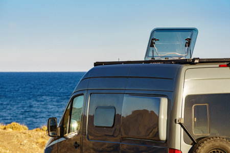 Sunroof, raisable panel window on roof top of rv camper van against blue sky. Traveling by motor home.の写真素材