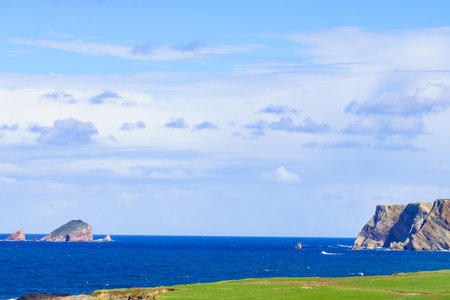 Sea shore, Asturias coast and Cape Penas high cliffs in the distance. Landscape in northern Spain.の写真素材
