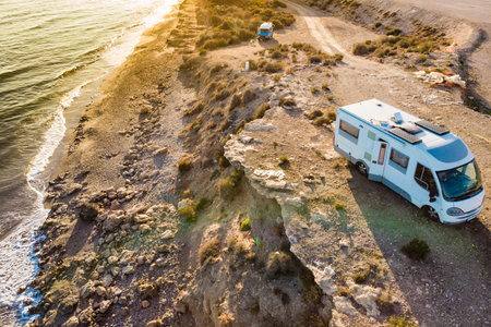 Caravan with solar panels on roof camp on coastal high cliff. Mediterranean sea in Spain. Motor home...