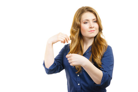 Young woman brushing long healthy brown hair, using hairbrush. Haircare.の写真素材