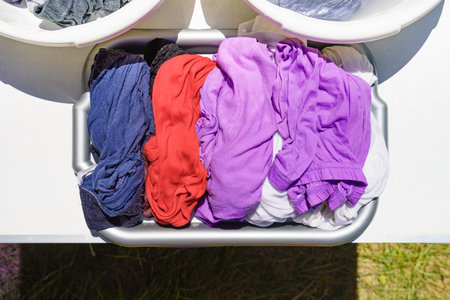Doing laundry on vacation trip. Bowls with washing clothes. Top down view.の写真素材