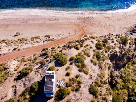 aerial view. Camper rv with tilt solar photovoltaic panels on roof camping on cliff sea shore in wintertime. Mediterranean region of Villaricos, Costa Almeria in Andalusia, Spainの写真素材