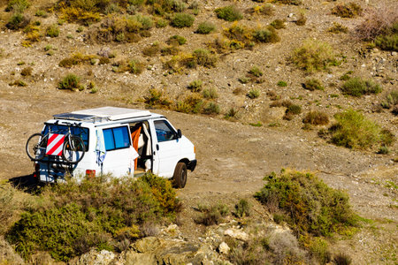 Van with bicycle equipment camping on nature. Vanlife holidays.