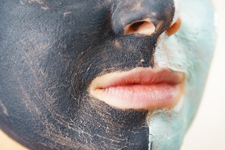 Woman cleaning skin face, using green mud and carbon black mask. Girl taking care of oily complexion. beauty procedures. skincare.の写真素材