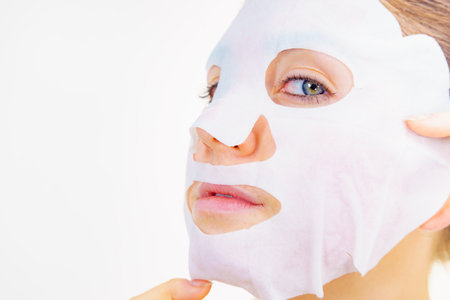 Woman with sheet mask on her face. Girl taking care of skin. Beauty treatment. Skincare.の写真素材