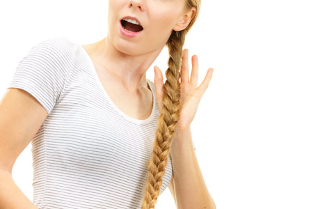 Blonde girl with long braid hair. Haircare, hairstyling, feminine style.の写真素材