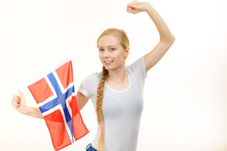 Blonde young woman teen girl braid hair holds norwegian flag. Scandinavian people.の写真素材
